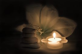 White amaryllis flower and zen stones lit purely by candlelight, very serene and calming situation